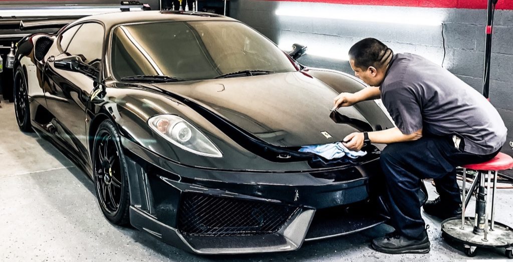 Paint protection film being applied to the front of a Ferrari 430