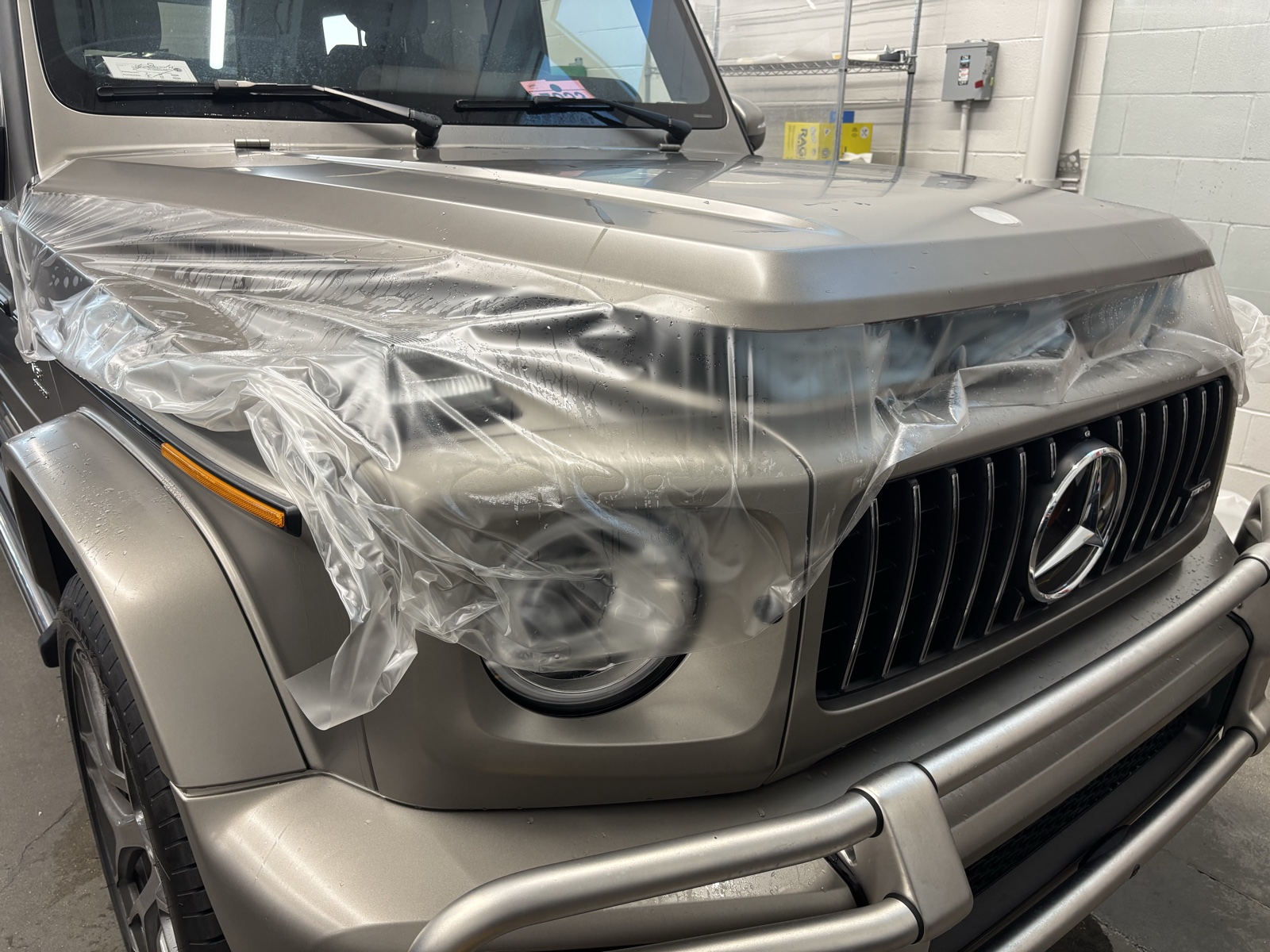 Matte paint protection film being applied around a Mercedes G-Wagon headlight